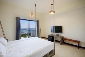 1 dormitorio con 1 cama y TV de pantalla plana en OceanSeeker, en Isla Verde