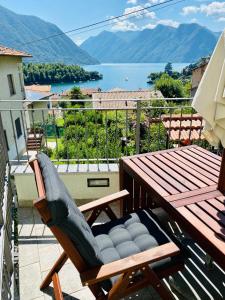 Lora Lake Villa في Ossuccio: شرفة مع طاولة وكراسي وإطلالة على الماء