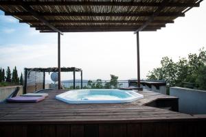 a hot tub sitting on a wooden deck with a roof at Roof Of The Galilee in Amirim
