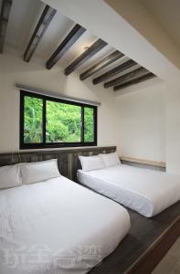 2 camas en una habitación con ventana en OceanSeeker en Green Island