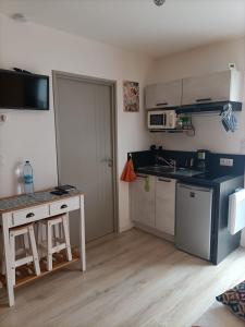 a small kitchen with a table and a microwave at Proche GR34 , Studio "Estrella" , petit cocon accueillant in Hillion