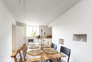 uma sala de jantar com uma mesa de madeira e cadeiras em Round House Cottage em Castle Cary
