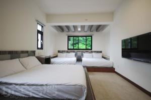 a bedroom with two beds and a flat screen tv at OceanSeeker in Green Island