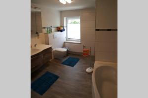 a bathroom with a tub and a toilet and a sink at Sonnenblick Rittersgrün II in Breitenbrunn