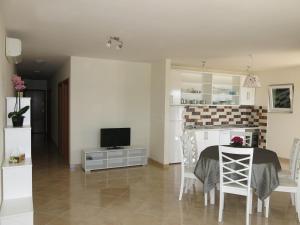 cocina y comedor con mesa y TV en Sunset Apartment, en Trogir
