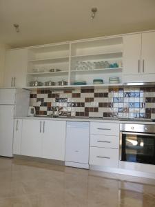 cocina con armarios blancos y fogones en Sunset Apartment, en Trogir