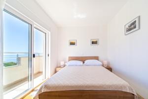 - une chambre avec un lit et une grande fenêtre dans l'établissement The View Apartments, à Split