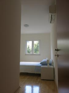 Habitación pequeña con cama y ventana en Sunset Apartment, en Trogir
