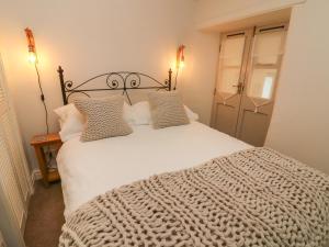 a bedroom with a large white bed with pillows at Nuthatch Cottage in Skipton