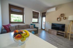 uma sala de estar com uma taça de fruta na mesa em Tarnovgrad Apartments - Free parking em Veliko Tŭrnovo