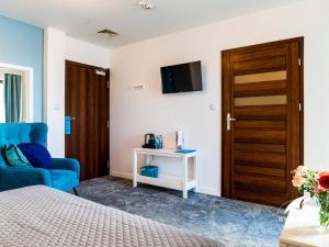 a bedroom with a bed and a blue chair and a door at White Sails Solina in Solina