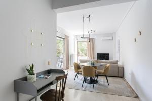 a living room with a table and chairs and a couch at Pleasant 2BR Apartment near HELEXPO by UPSTREET in Athens