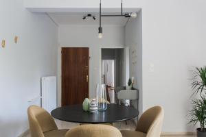 a dining room with a black table and chairs at Pleasant 2BR Apartment near HELEXPO by UPSTREET in Athens