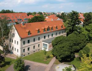 einen Blick über ein großes Gebäude mit orangefarbenem Dach in der Unterkunft Gutshof Hauber in Dresden
