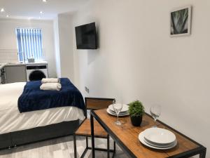 um quarto com uma cama e uma mesa com pratos em 10min to City - FREE Parking - Private Studio - Contractor Friendly em Manchester