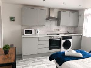 uma cozinha com electrodomésticos brancos e uma cama num quarto em 10min to City - FREE Parking - Private Studio - Contractor Friendly em Manchester