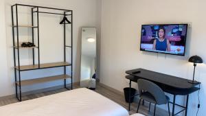 a room with a television and a bed in it at Pombal Rooms Santiago in Santiago de Compostela
