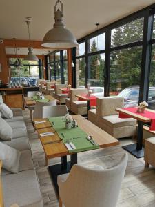 um restaurante com mesas, cadeiras e janelas em Alpengasthof Tanzstatt em Lachtal