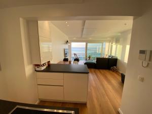 a kitchen and living room with a view of the ocean at Nieuwpoortnachten res. Rubens in Nieuwpoort