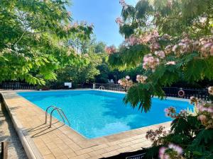 una piscina circondata da alberi e fiori di Casale San Giovanni a Cura Nuova