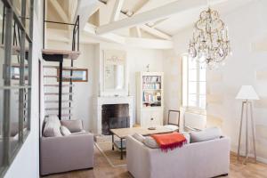 a living room with a fireplace and a chandelier at XVIII Century Gem With Magnificent Views Of The Harbour with a private garage in Saint-Martin-de-Ré