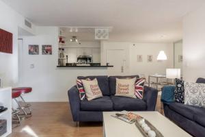 a living room with a blue couch and a table at Renovated cozy The yacht club at aventura Parking included in Miami