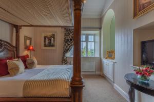 a bedroom with a large bed and a large window at Cabra Castle Hotel in Kingscourt