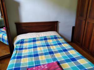 een bed met een blauwe en gele quilt bij House Anna in Gonio
