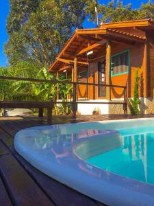 a house with a swimming pool in front of a house at Hindu Box Containers e Cabanas in Praia do Rosa