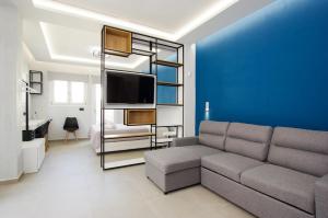 a living room with a couch and a blue wall at DORADO ACCOMODATION in Heraklio