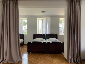 1 dormitorio con 1 cama negra frente a 2 ventanas en House 122, en Kobuleti