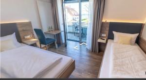 een hotelkamer met 2 bedden en een balkon bij Hotel Mediterra in Uhldingen-Mühlhofen