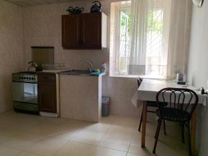 a kitchen with a stove and a table and a window at House 122 in Kobuleti