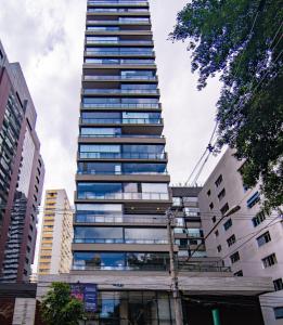 een hoge wolkenkrabber in een stad met gebouwen bij 360 VN Capote Valente by Housi in Sao Paulo