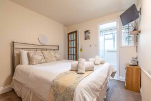 um quarto com uma cama grande e uma televisão em CENTRAL WINDSOR, 2 BEDROOM 2 BATHROOM, 5 MINUTES TO CASTLE em Windsor