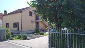 uma cerca em frente a uma casa com um edifício em Hostel Vera - Airport Podgorica em Podgorica