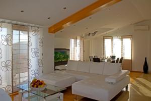 uma sala de estar com um sofá branco e uma mesa em Apartments Selak em Split