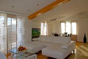 a living room with a white couch and a table at Apartments Selak in Split