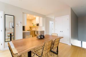 a dining room with a wooden table and chairs at Trendy Little Italy 3 Bedroom Condo by Den Stays in Montreal