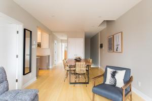 a living room with a dining room table and chairs at Trendy Little Italy 3 Bedroom Condo by Den Stays in Montreal
