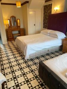 1 dormitorio con 2 camas y suelo de baldosa en The Traxx Hotel en Bangor