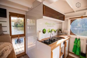 een keuken in een caravan met een wastafel en een raam bij WOHLFÜHLBOOT Hausboot - Festlieger im Hafen Bad Saarow - WC an Bord, Dusche an Land in Bad Saarow
