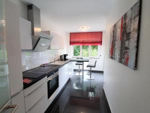 a kitchen with white cabinets and a black counter top at Ihr Ticket ins Grüne - Topmoderne 5-Sterne-Ferienwohnung in Bad Kreuznach