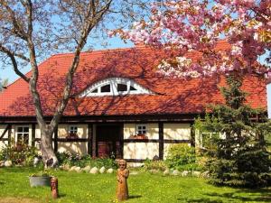 een huis met een rood dak en een standbeeld ervoor bij Ruegen Fewo 119 in Groß Schoritz