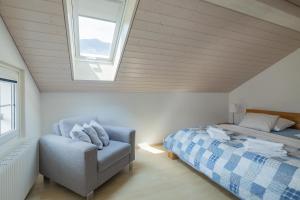 a bedroom with a bed and a chair and a window at Mohn in Interlaken