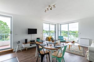 sala de estar con mesa, sillas y sofá en Bella Vista - Face mer La Baule - 5 personnes, en La Baule