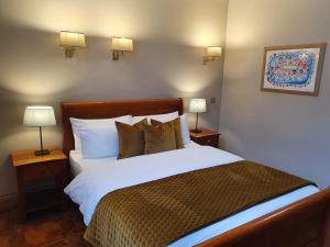 um quarto com uma cama grande e 2 candeeiros em Uppercross House Hotel em Dublin