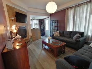 uma sala de estar com um sofá e uma mesa em Gîte Shoreline de la terre à la mer em Rivière-la-Madeleine