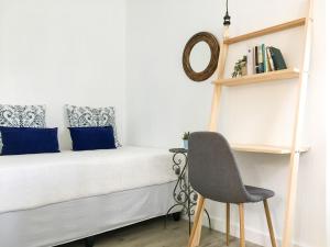 een kleine slaapkamer met een bed en een stoel bij Comfort Zone in Johannesburg