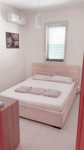 - une chambre blanche avec un grand lit blanc et une fenêtre dans l'établissement Le Ville 1 Costa Saracena, à Agnone Bagni